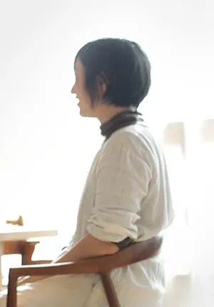 木製の椅子に座る女性